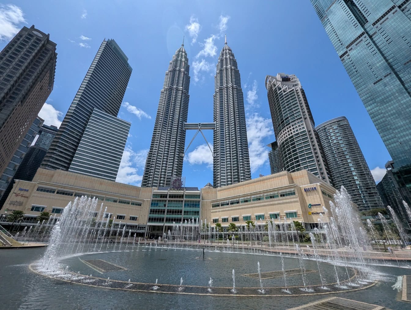 Petronas Twin Towers viewed from KLCC park with fountains in foreground showing daytime photography perspective