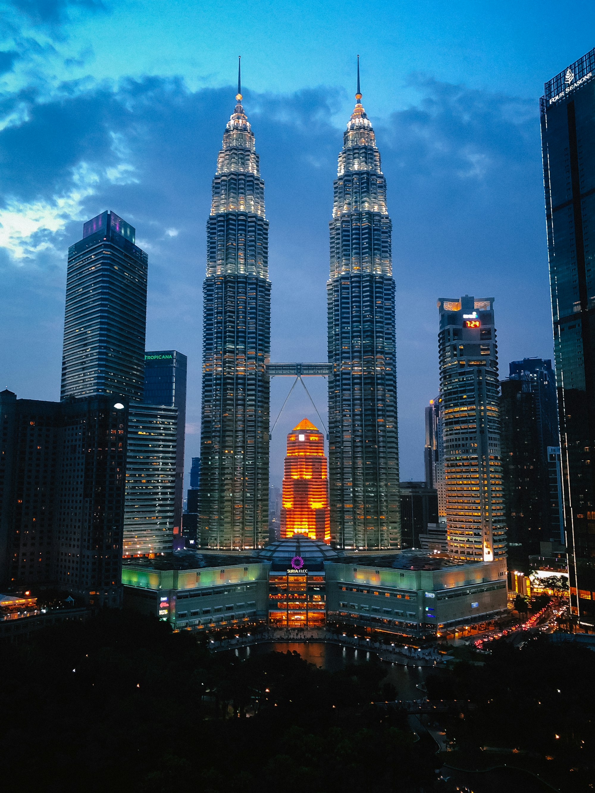 Petronas Twin Towers illuminated at night rising above Kuala Lumpur cityscape